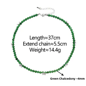 Macro detail of 4mm green chalcedony beads with delicate silver butterfly charms