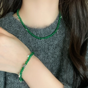 Detailed view of green chalcedony bead necklace and bracelet set with silver butterfly charms