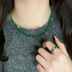 Detail of green chalcedony beaded necklace with silver star charms and bow ring