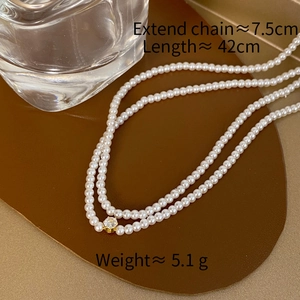 Detail of multi-layer pearl necklace with gold pendant and dimension specifications