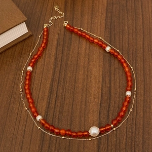 Detail view of a double-layer vintage necklace with red agate beads and natural pearls