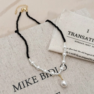 French style necklace with black crystals and pearls on minimalist linen background