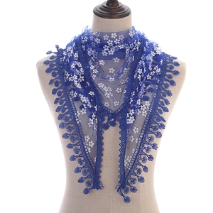 Detailed close-up of blue lace triangle scarf with white daisy floral prints