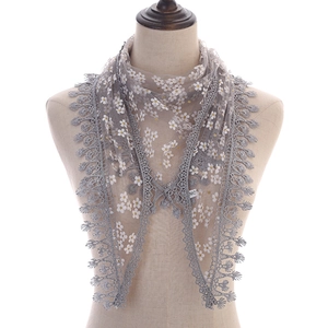 Detail of grey lace triangle scarf with yellow daisy print and crochet tassel edge