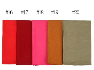 Detail view showing mercerized cotton scarves in five solid colors with refined edges
