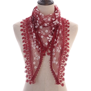 Dark red triangle lace scarf with white floral patterns and tassel trim on mannequin