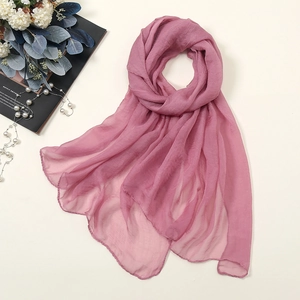 Detail of dusty pink chiffon scarf showing fine rolled edges and semi-transparent texture