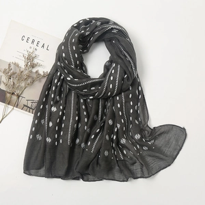 Close-up of lightweight dark grey linen scarf with white polka dots and stripes
