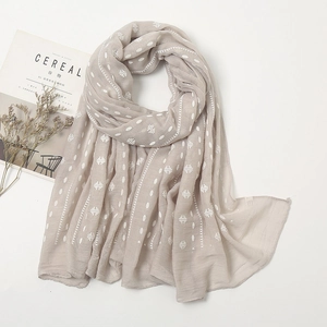 Detail of lightweight embroidered scarf with white polka dots and magazine decor