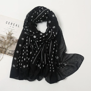 Detail of lightweight black linen scarf with white polka dots and stripes on white background