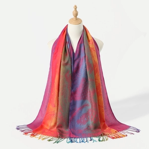 Scialle sfumato arcobaleno con ricami paisley e lunghe nappe su un manichino da esposizione