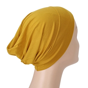 Close-up of ginger yellow modal turban hat showing soft pleated fabric and stretch texture