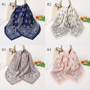 Vier verschiedene Satin-Halstücher mit Paisleymuster in diversen Farben an einer Tasche.