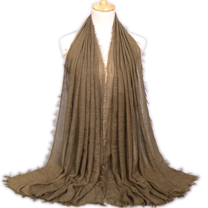 Olive green cotton linen scarf with frayed tassel edges shown on a white mannequin
