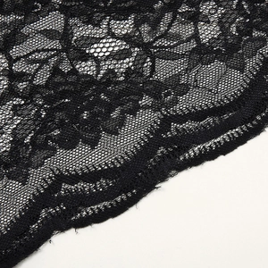 Vue détaillée du tissu en dentelle florale noire avec bordure cil et maille fine