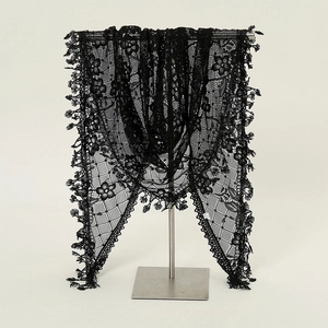 Close-up of black lace triangle scarf featuring floral embroidery and elegant fringe