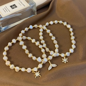 Elegant baroque pearl bracelet with gold beads and sparkling rhinestone charms on silk