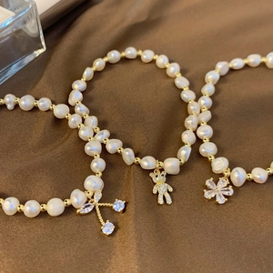 Elegant freshwater pearl bracelets featuring zircon bear, flower and bow charms on satin