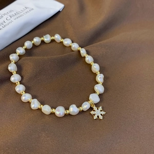 Detailed macro view of freshwater baroque pearls and a diamond snowflake pendant on silk