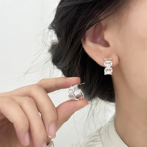 Silver hollow heart-shaped C-style stud earrings with intricate filigree engraving