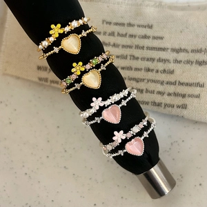 8pcs set of minimalist heart and flower rings with pearl accents on black props