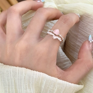 Close-up of pink heart gemstone ring and pearl band with a small flower detail
