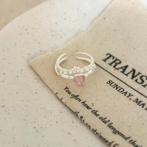 Detail of double-layer silver ring with pink heart stone, pearls and enamel flower