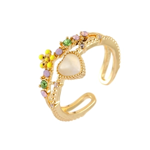Detail of adjustable gold ring with opal heart, yellow flower and colorful rhinestones