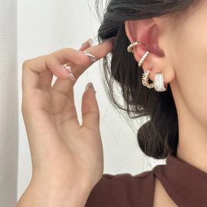 Elegant gold-plated ear cuff set with pavé cubic zirconia worn on a model's ear