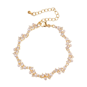 Elegant gold bracelet with irregular pearls and cubic zirconia stones on white background