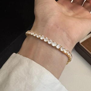 Elegant gold plated tennis bracelet with sparkling zircon stones worn on wrist
