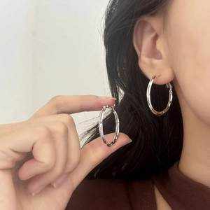 Boucles d'oreilles créoles torsadées en argent au design géométrique et minimaliste