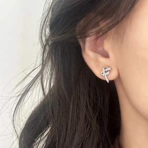 Boucles d'oreilles nœuds en argent avec zircons brillants portées par un mannequin femme