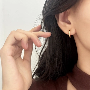 Classic minimalist 18K gold plated hoop earrings for women shown on ear in macro detail
