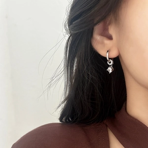 Elegant silver hoop earrings with a sparkling zircon pendant shown on a female model