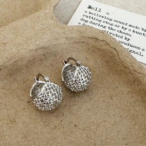 Macro shot of silver-tone basket-weave hoop earrings with textured 3D design