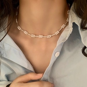 Minimalistische parelketting met bloemclusters en zilveren ketting op model