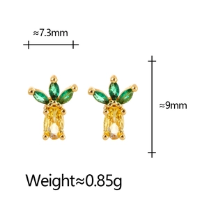 Macro shot of gold pineapple stud earrings with green and yellow crystal inlay