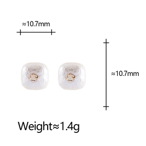 Gros plan détaillé des boucles d'oreilles carrées en perles de coton et détails dorés