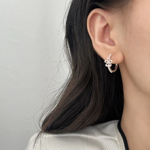 Silver flower hoop earrings with hollow petals and small pearls on model