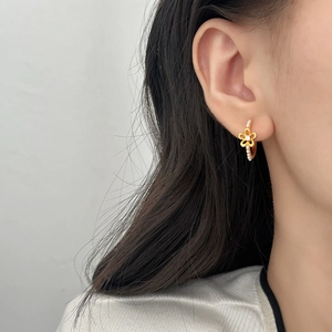 Elegant gold hollow flower earrings with pearl accents worn on model for a chic look