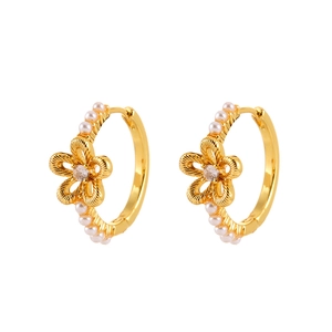 Elegant gold openwork flower hoop earrings with pearls and zircon on white background