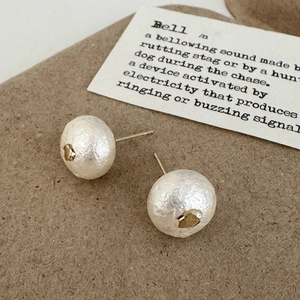 Vue macro détaillée de boucles d'oreilles en perles de coton avec détails dorés raffinés