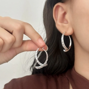 French style textured silver crossover spiral hoop earrings with diamond-cut finish