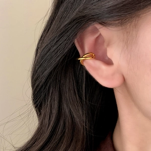 Polished gold double-ring crossover ear cuff worn on the ear for a minimalist look