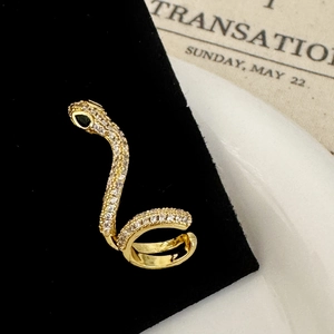 Détail de la manchette d'oreille serpent dorée avec zircons et œil en gemme verte