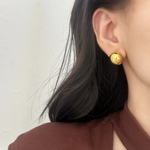 Polished gold-plated dome stud earring worn by a model for a stylish minimalist look