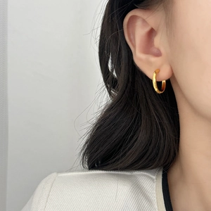 Créoles dorées minimalistes avec finition polie portées pour un style quotidien élégant
