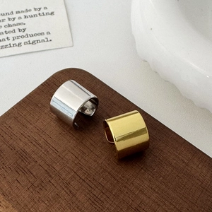 Minimalist wide C-shape ear cuffs in polished gold and silver finish on wooden display