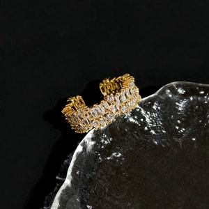 Macro detail of gold plated ring with shimmering cubic zirconia on glass tray